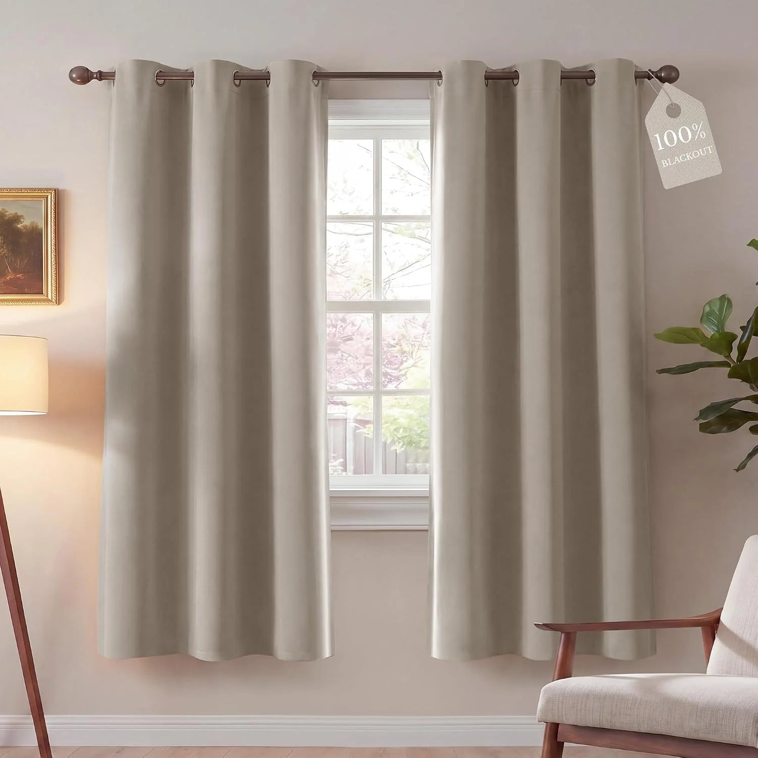 Greige blackout grommet curtains hanging over a window in a modern living room.