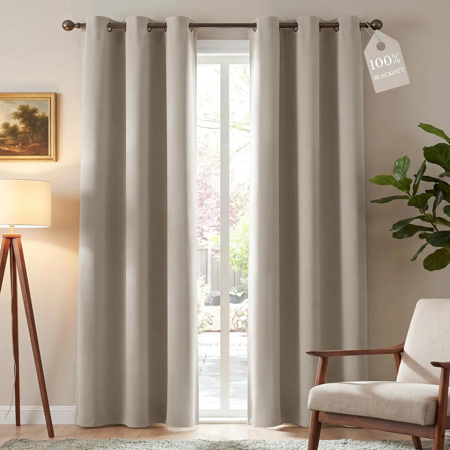 Pair of greige 100% blackout curtains with metal grommets on a rod in a bright room.
