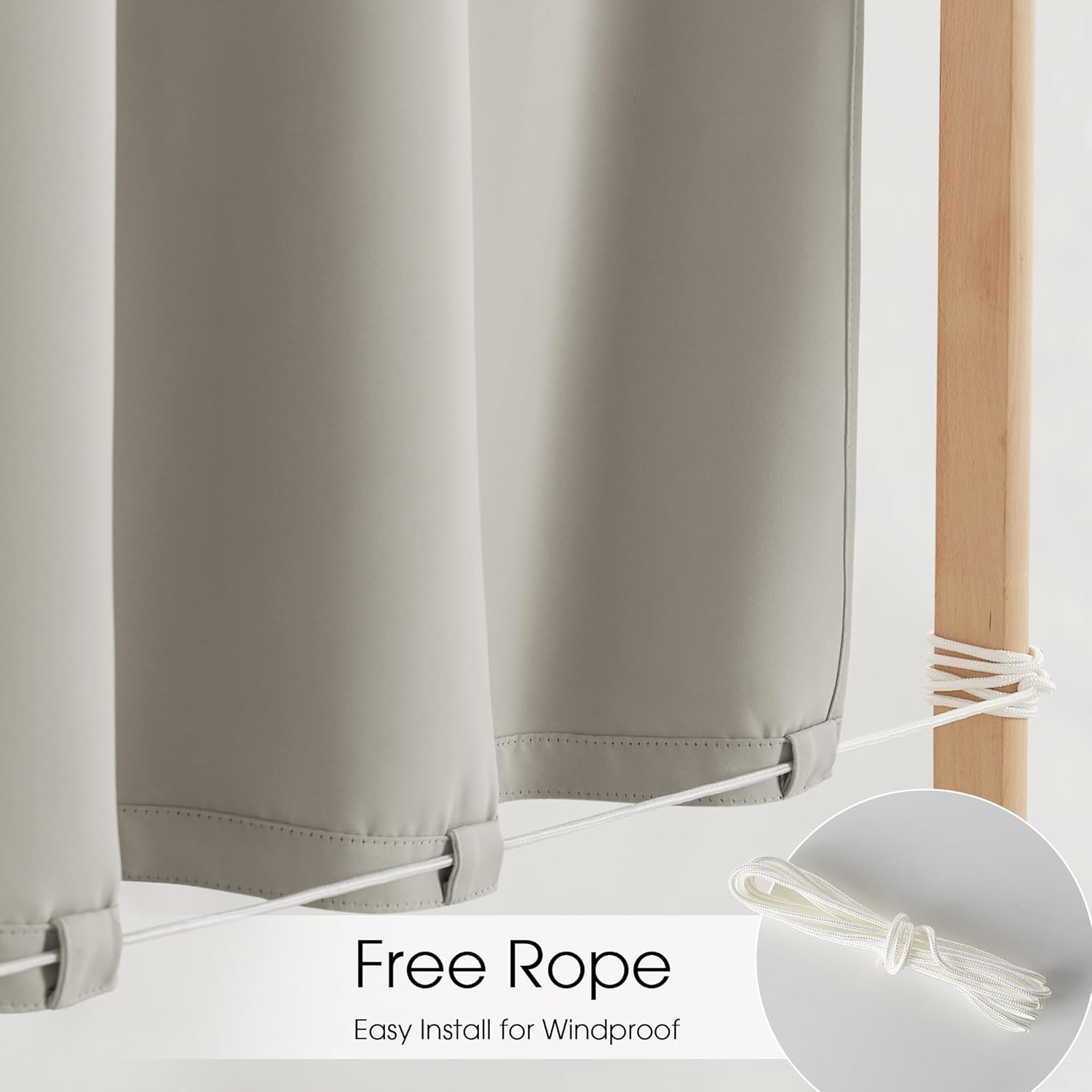 Greige outdoor windproof curtains with bottom loops, secured by white rope to wooden post. Rope detail.