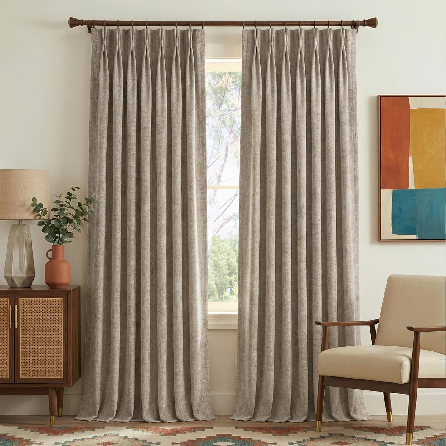 Greige textured pinch pleat curtains hanging on a dark wood rod in a modern living room.