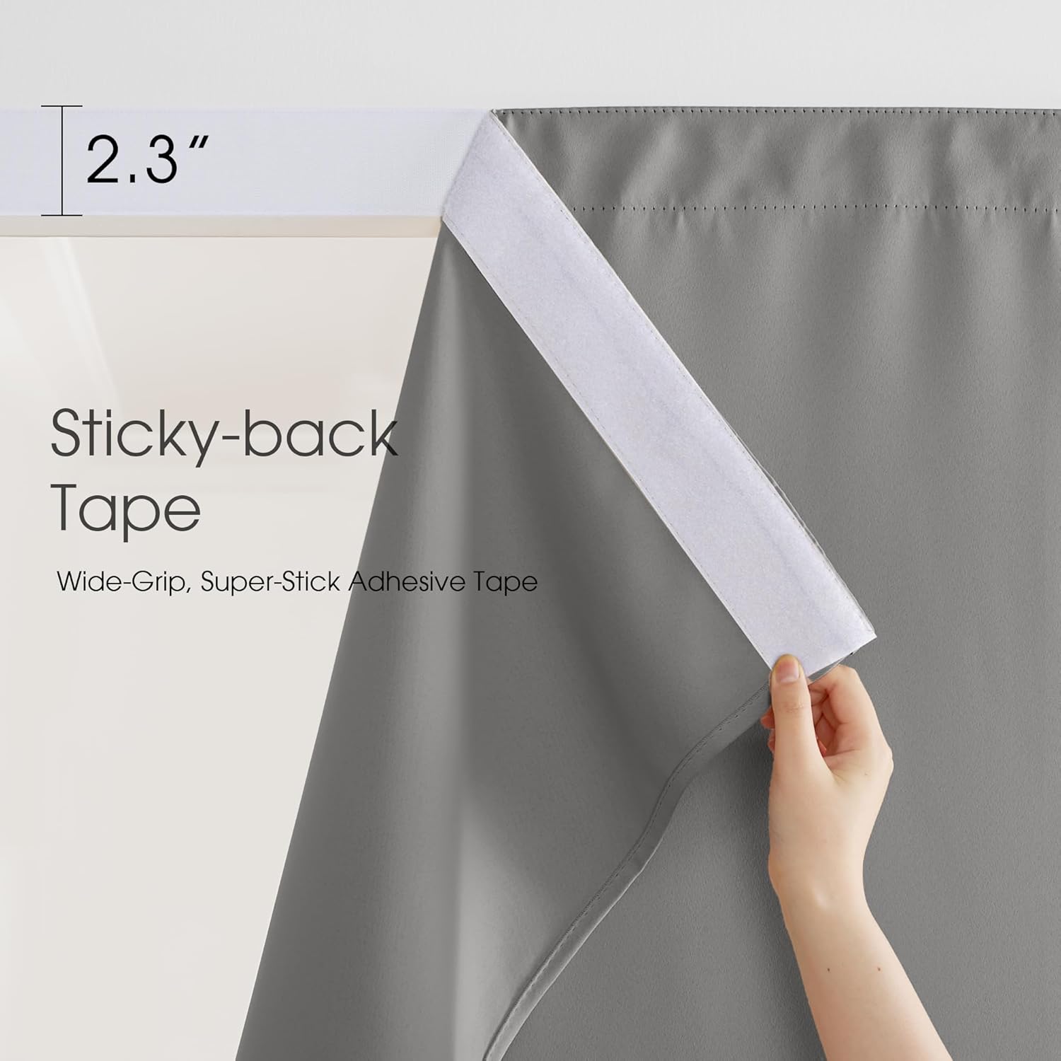 Hand shows 2.3 inch wide sticky-back tape on top edge of grey adhesive blackout curtain.