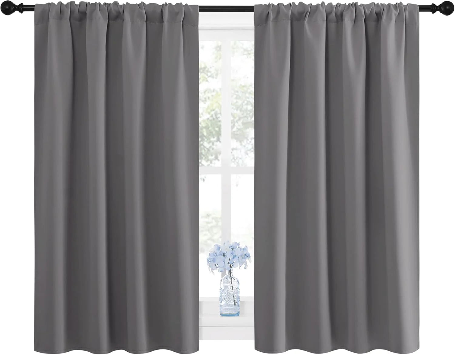 Pair of grey blackout curtains with a gathered rod pocket top over a window