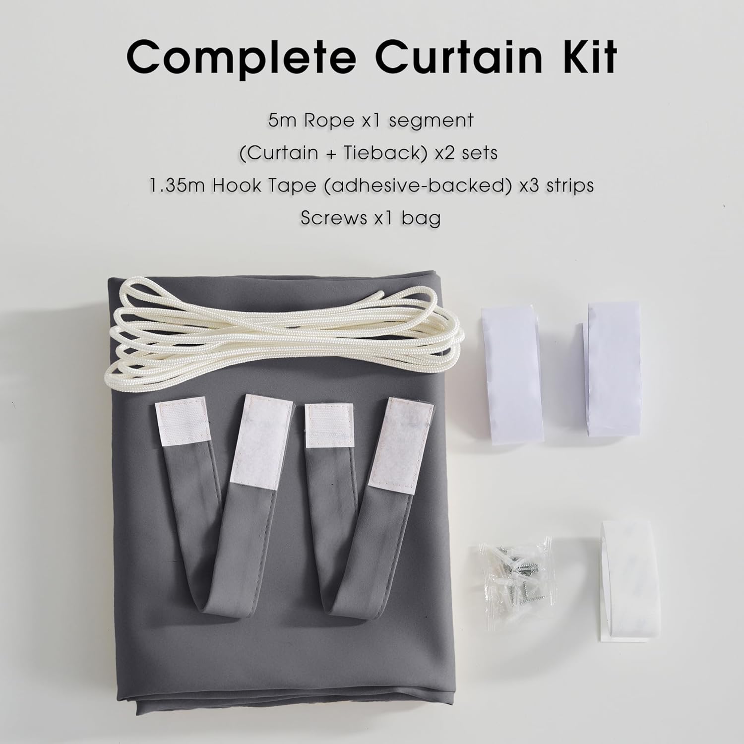 Grey curtain kit with folded fabric, white rope, adhesive hook tape strips, and hardware bag.