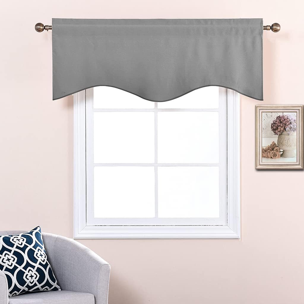 Smooth grey fabric window valance with scalloped bottom edge, hung on a bronze rod above white window.