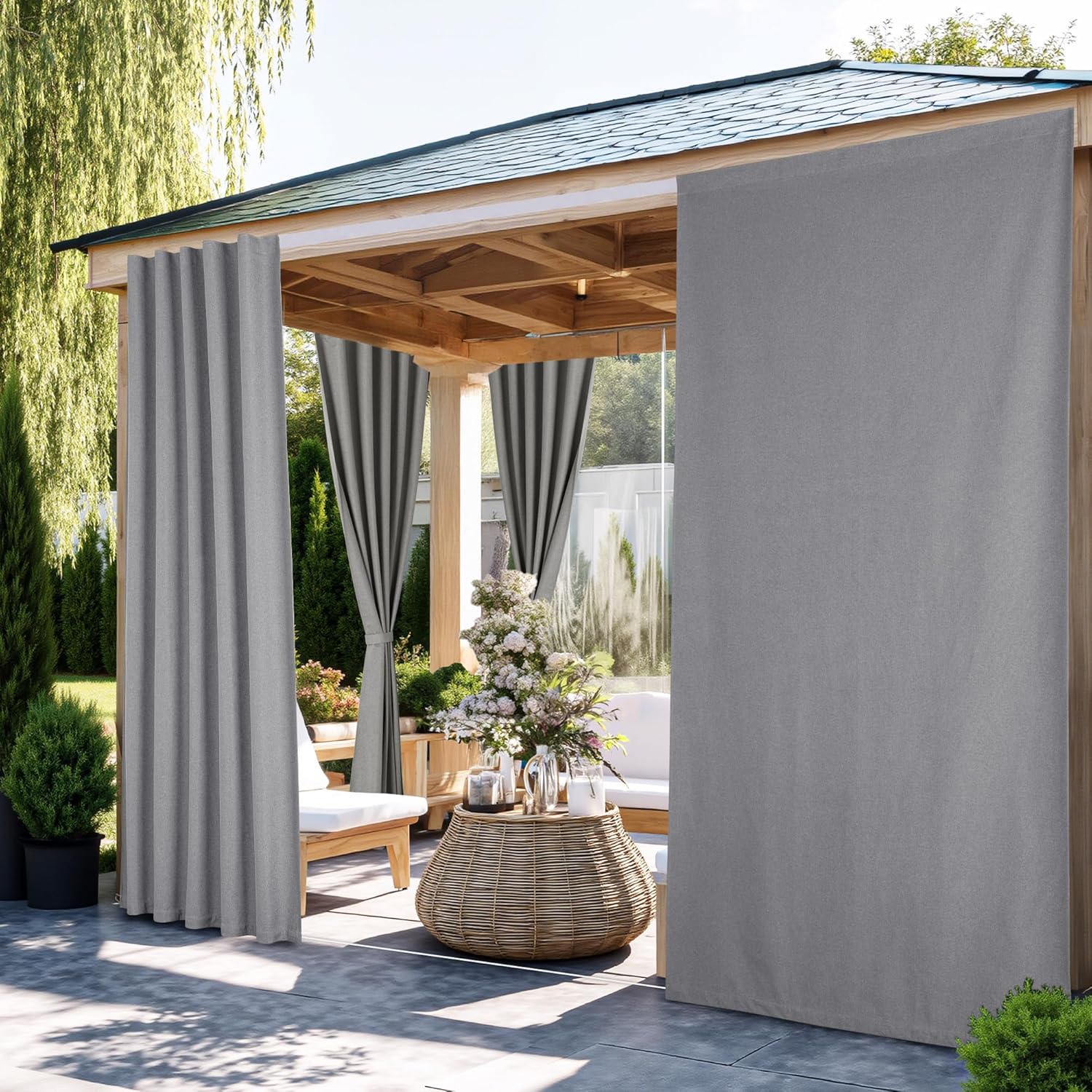 Solid grey outdoor privacy curtains hanging from a wooden gazebo, offering shade and privacy for a patio.