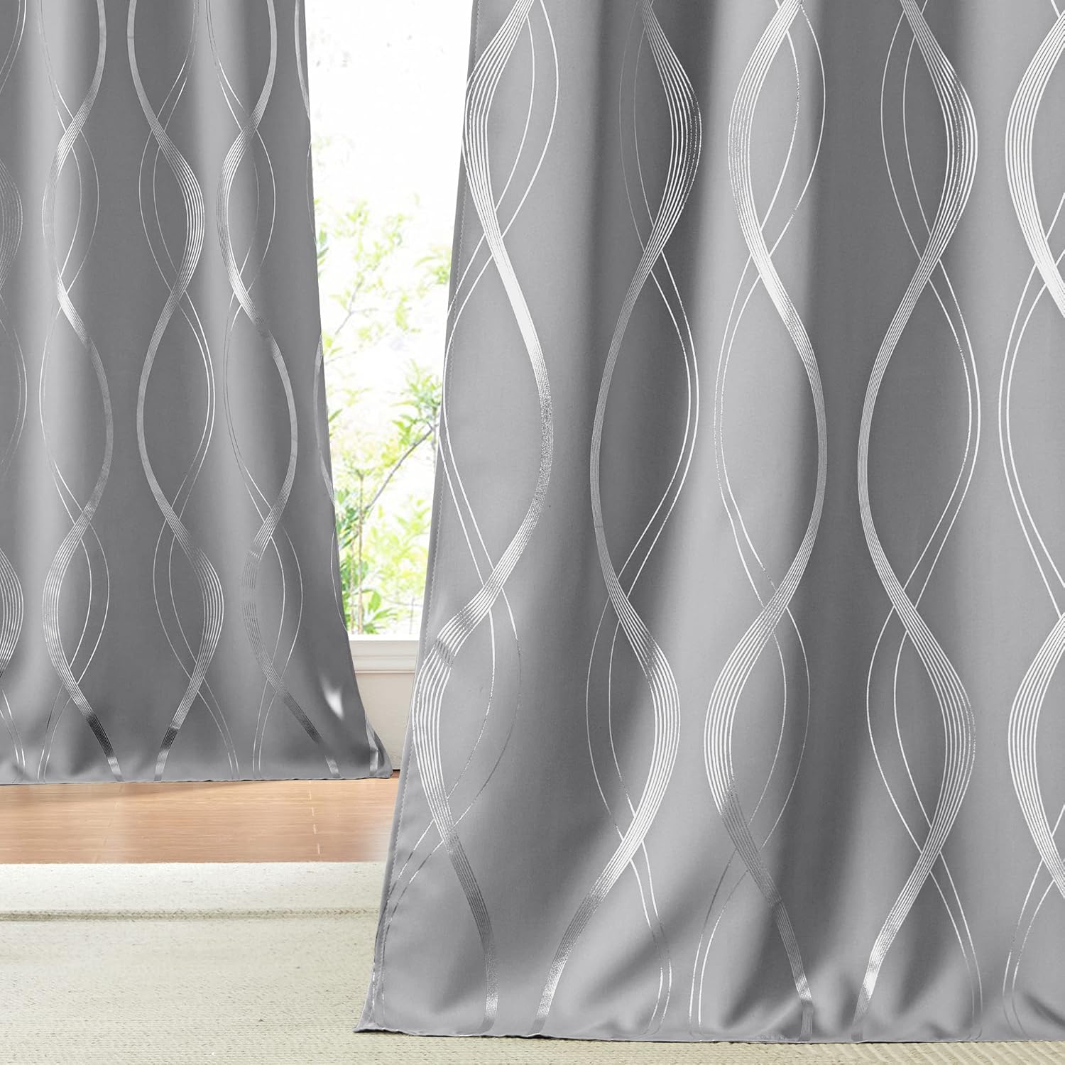 Close-up of modern grey curtains with shimmering silver wavy geometric pattern, hanging by a window.