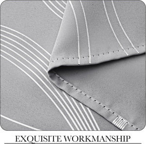 Close-up of light grey woven fabric with reflective silver vertical stripes and a neatly stitched hem.