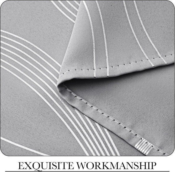 Close-up of light grey woven fabric with reflective silver vertical stripes and a neatly stitched hem.