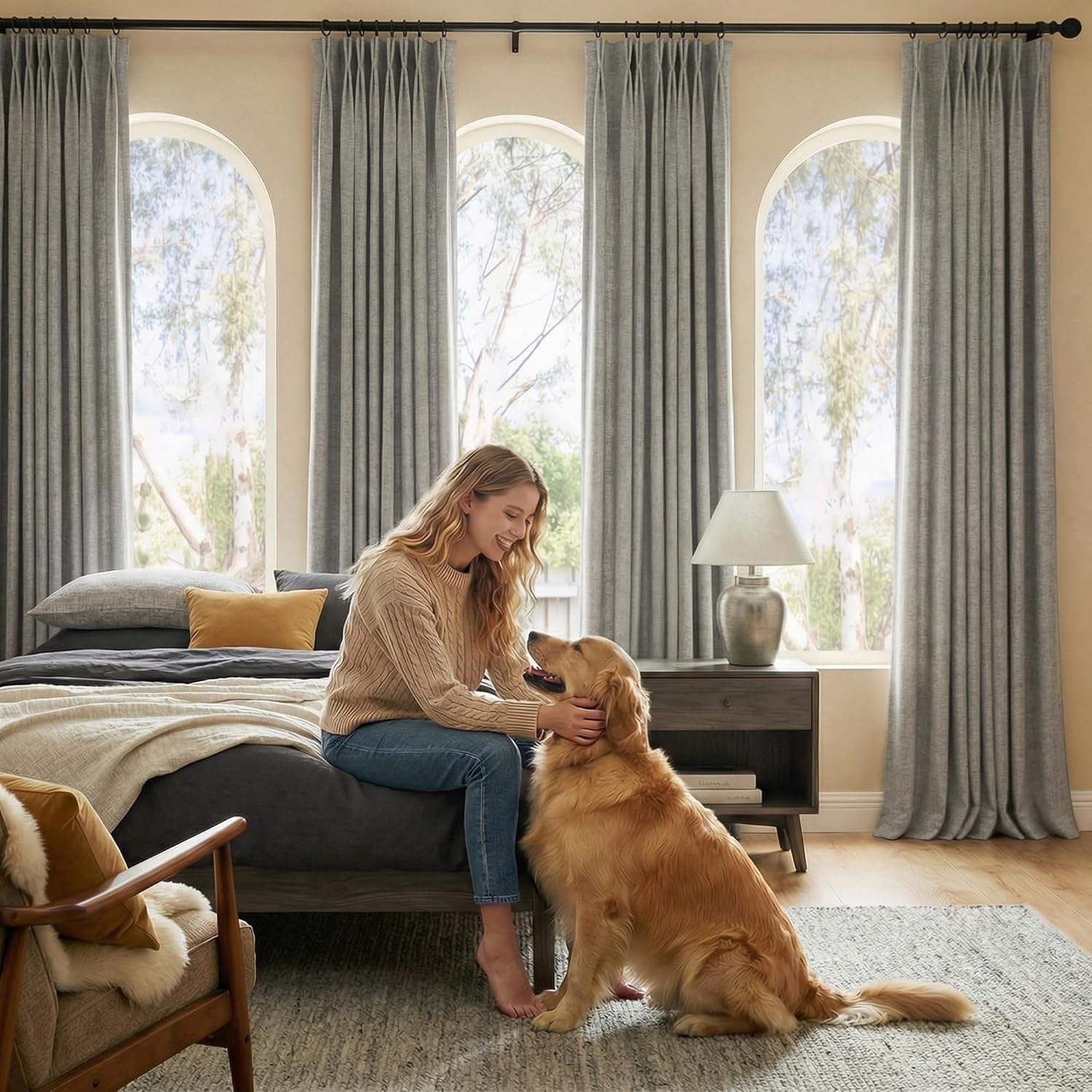 Heather gray pleated linen-look curtains hang on black rods framing arched bedroom windows.