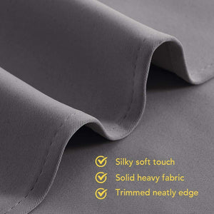 Close-up of a heavy, dark gray curtain fabric with a silky soft texture and neatly stitched, trimmed edge.