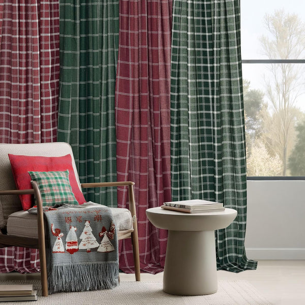Red and green plaid curtains with white grid pattern, hanging by a window in a festive holiday setting.