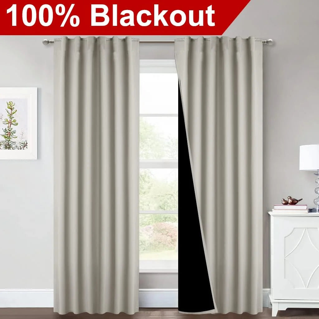 Ivory blackout curtains on a silver rod in a bright bedroom window scene