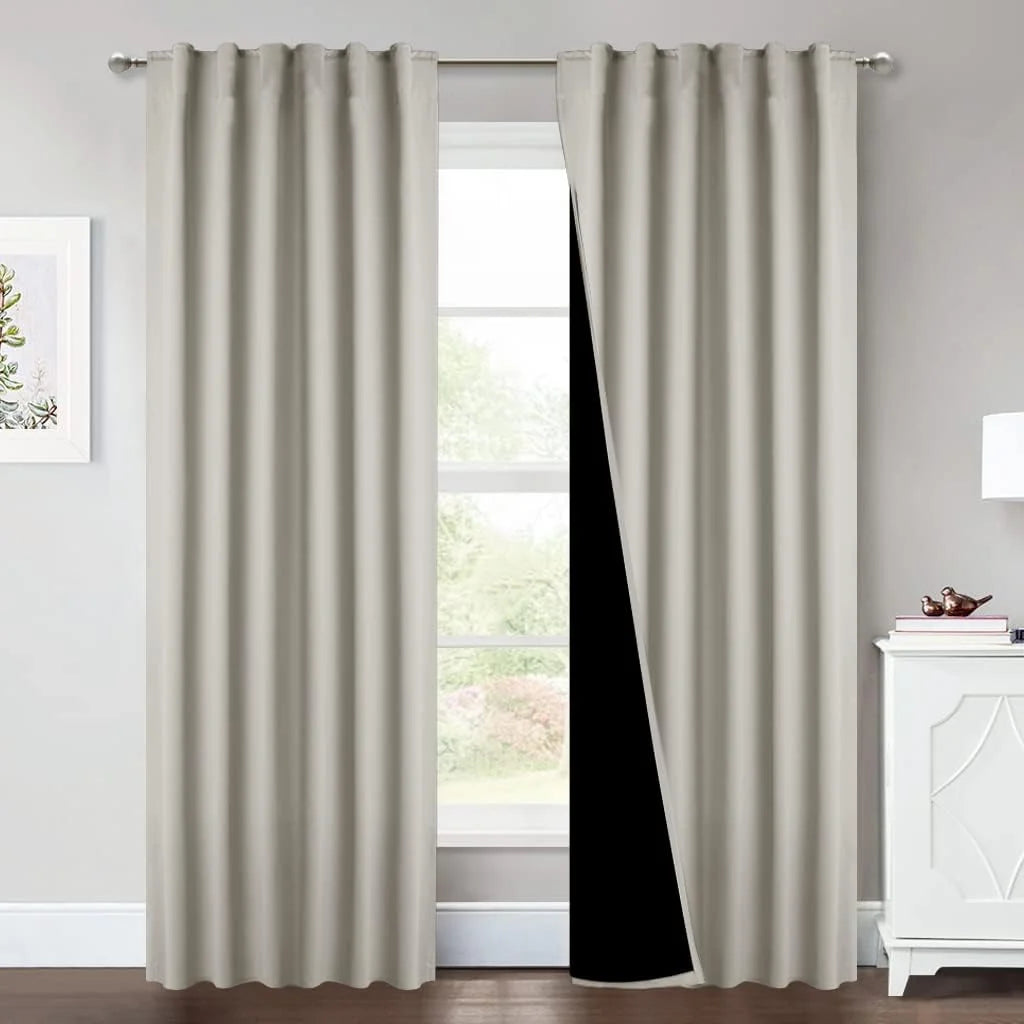 Ivory blackout curtains on a silver rod with black lining in a bright room