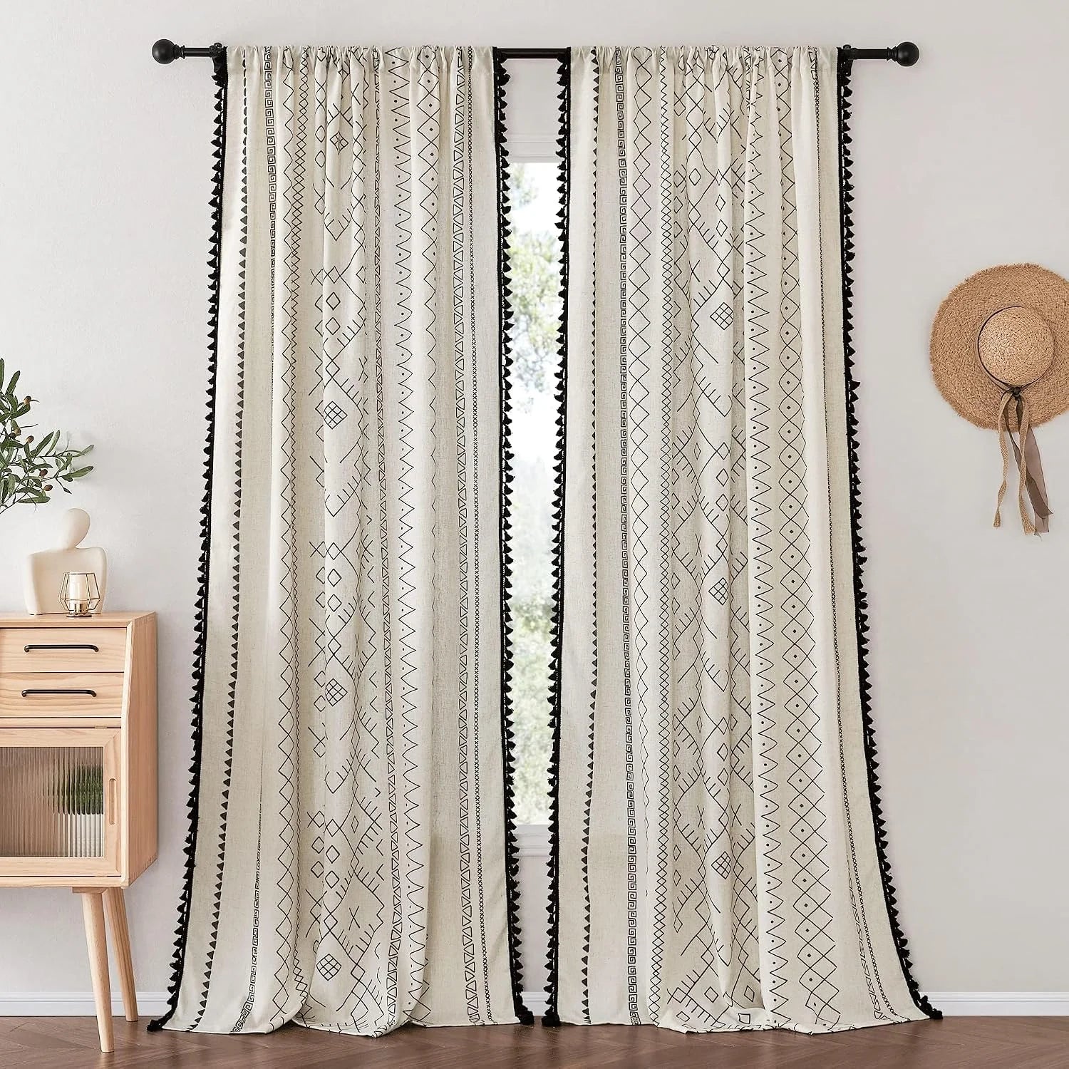 Ivory boho curtains with black geometric print and tassel trim on black rod