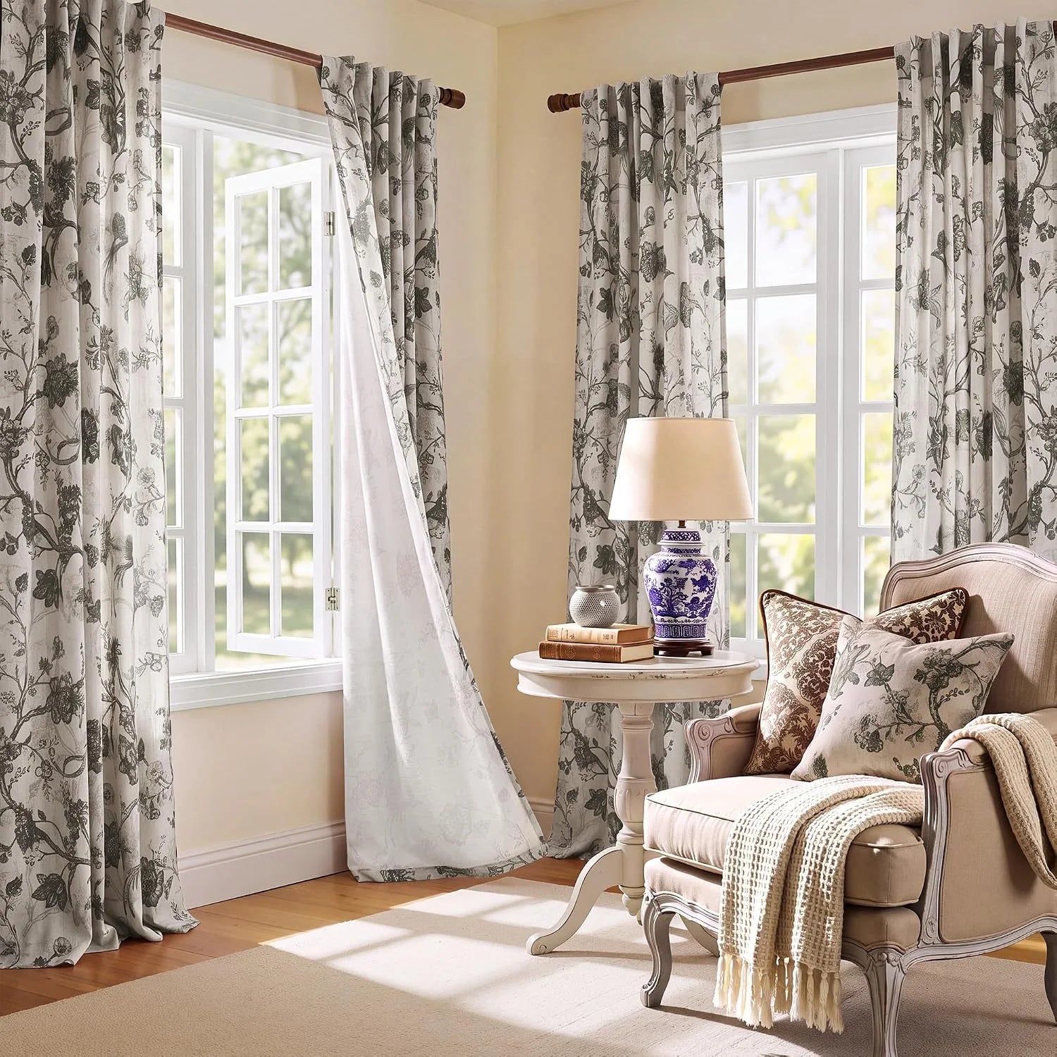 Ivory curtains with gray botanical print hanging on wood rods in a cozy sitting room