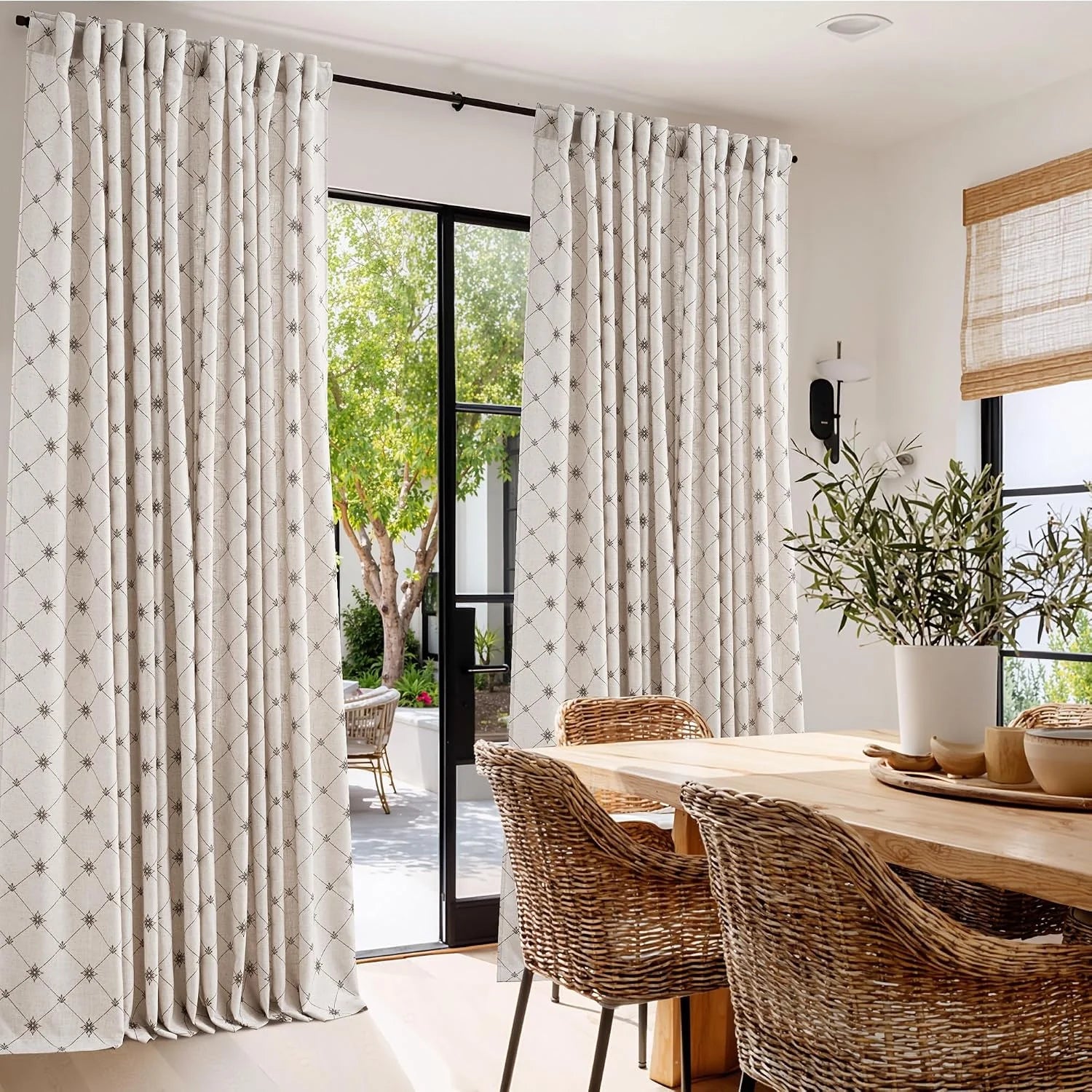 Ivory geometric patterned curtains on a black rod in a bright modern dining room