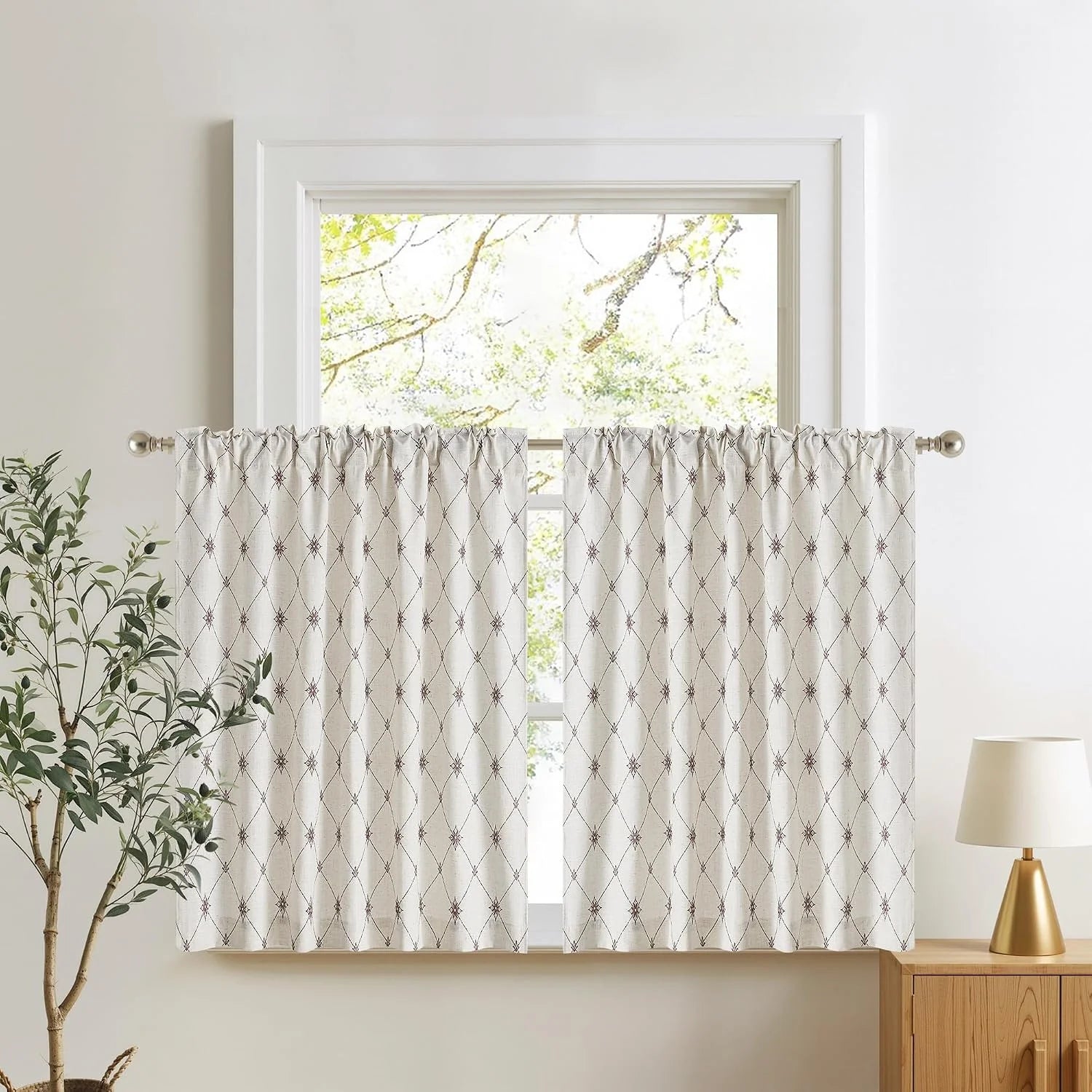 Ivory geometric linen-look tier curtains on a silver rod in a bright modern room