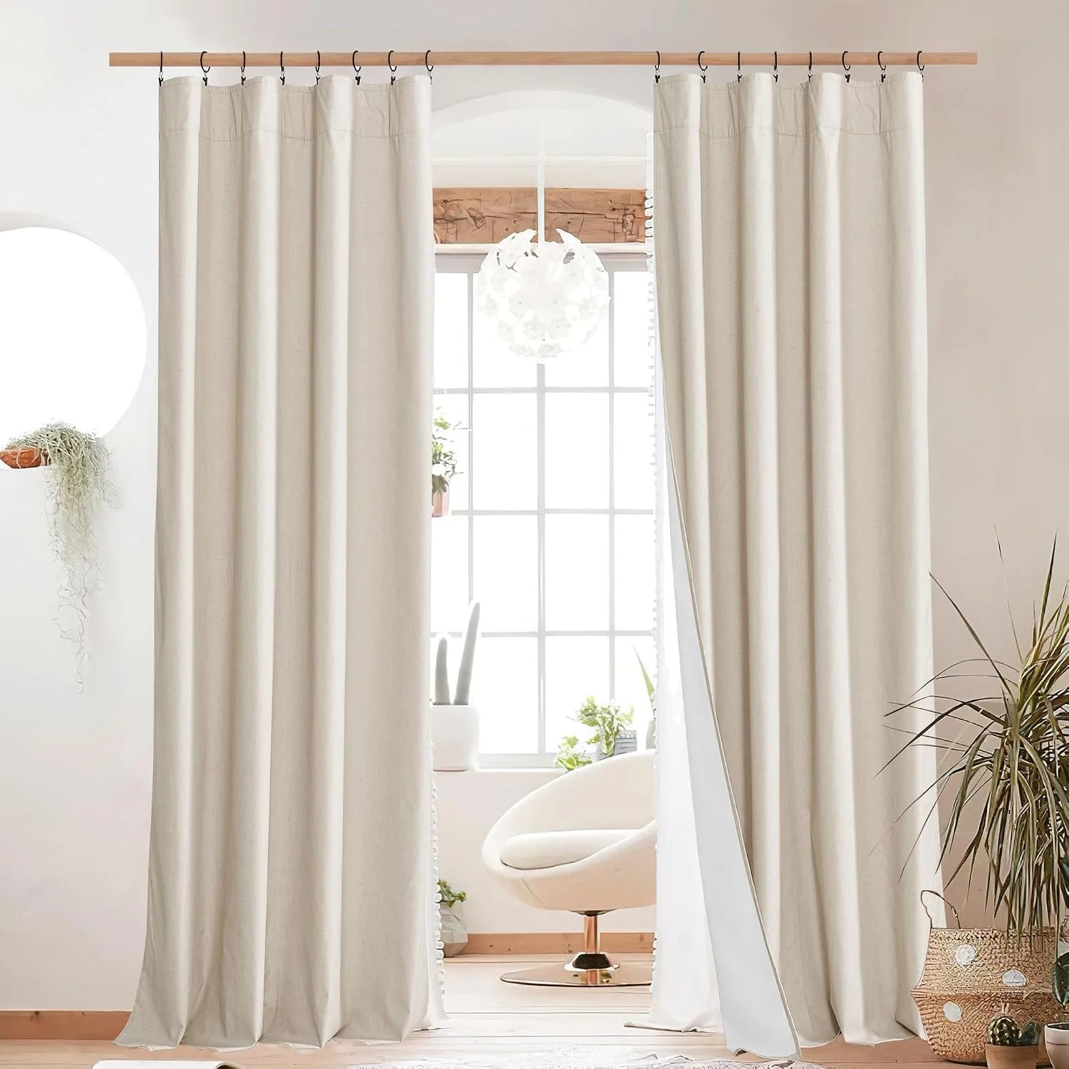 Ivory linen curtains on a wooden rod framing a bright window in a modern room
