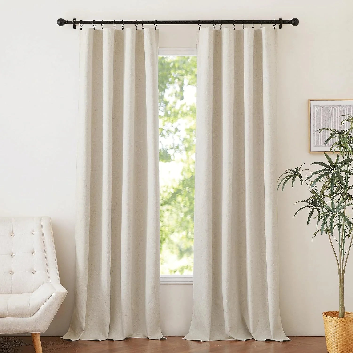 Ivory linen-look curtains hanging from black ring hooks in a bright minimalist room
