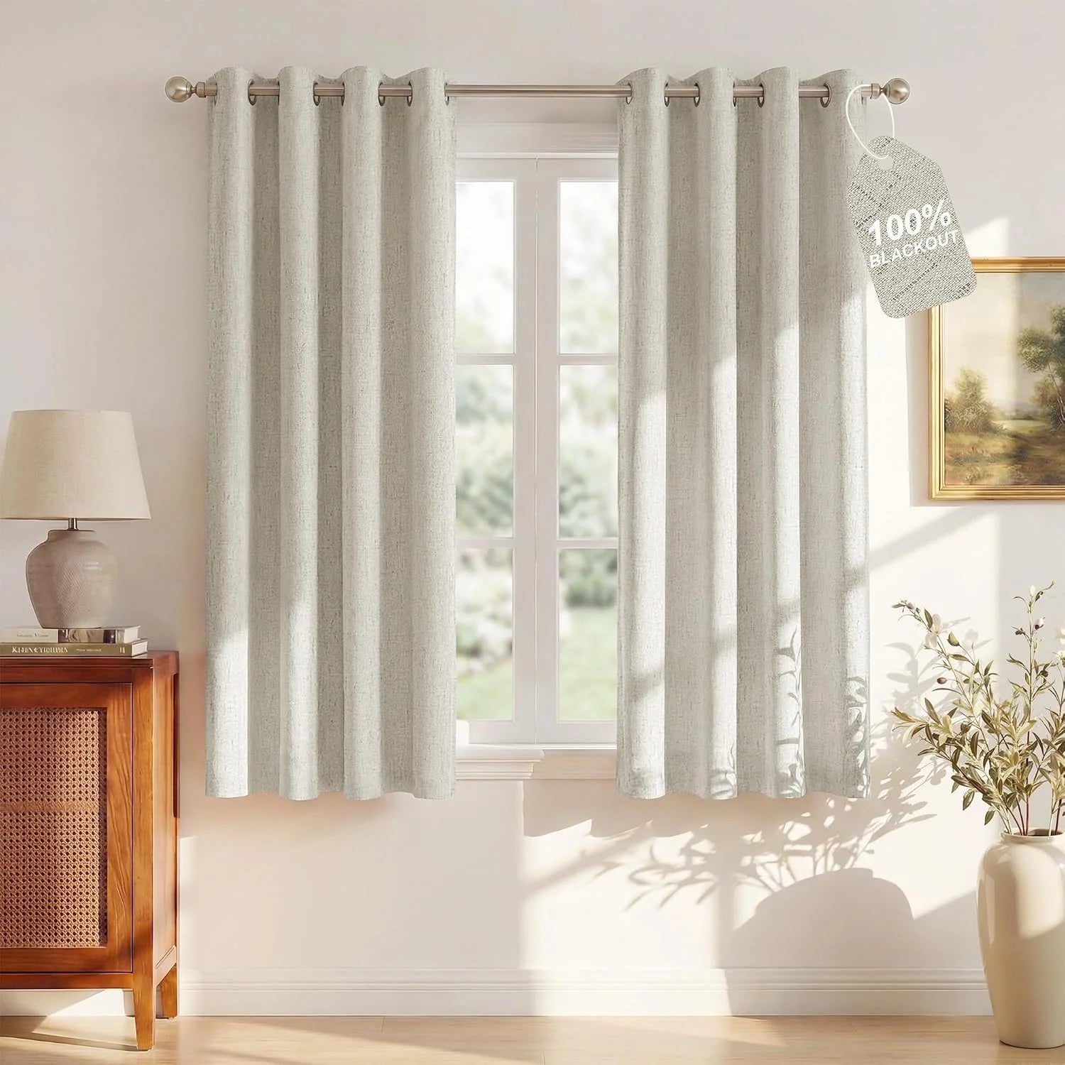 Ivory linen-look blackout curtains with grommet top hanging in a bright neutral room