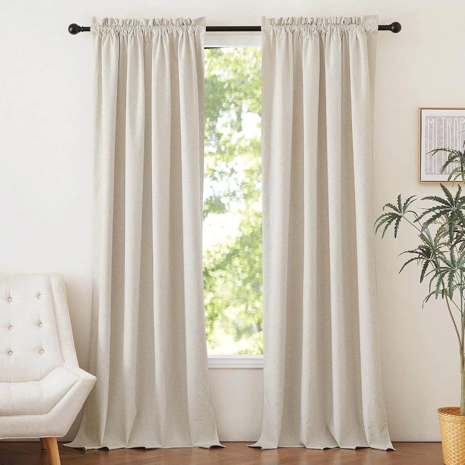 Ivory linen-look rod pocket curtains hanging on a black curtain rod in a bright room
