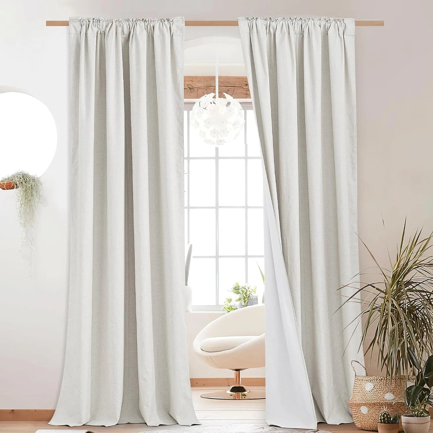 Ivory linen-look rod pocket curtains framing a bright window in a minimal room