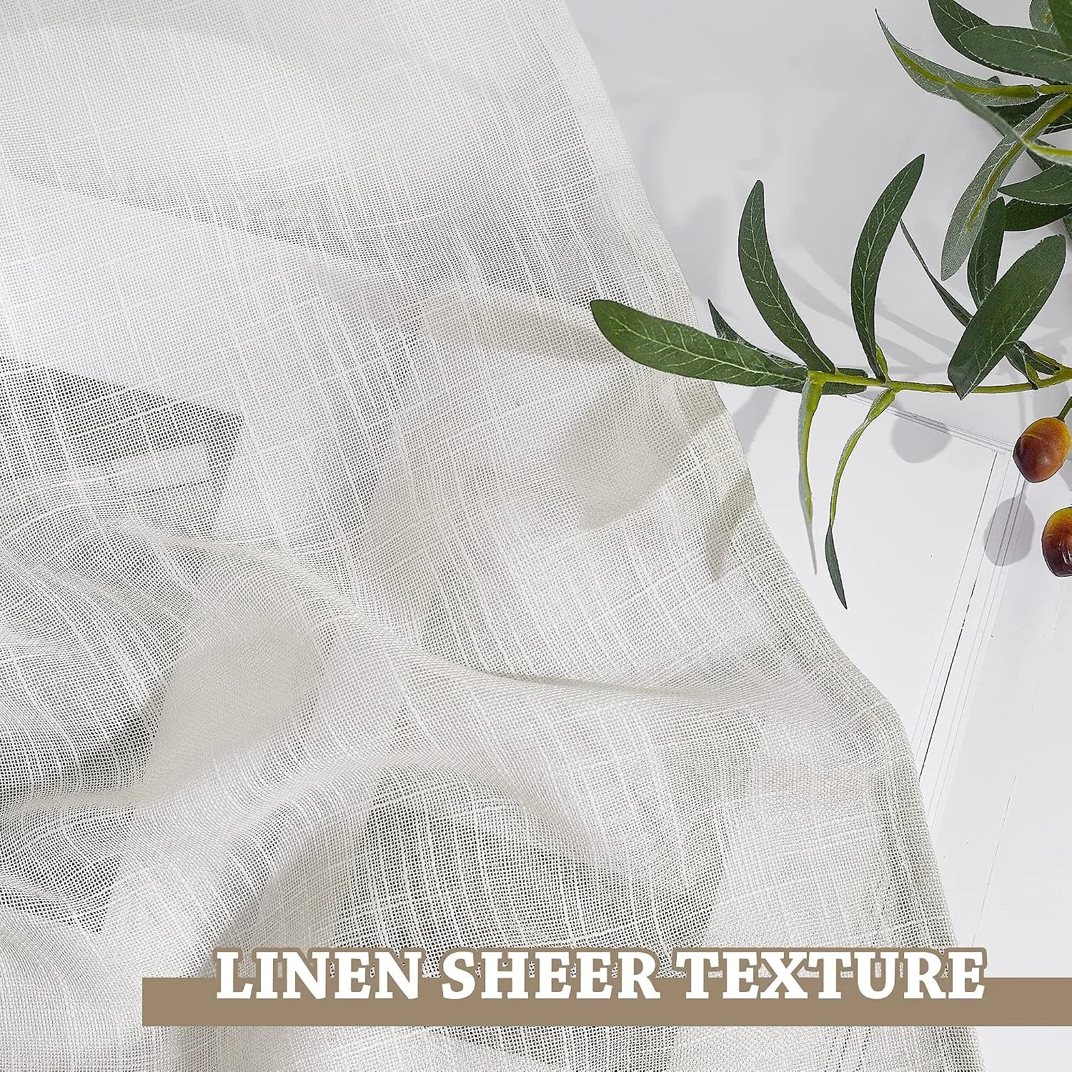 Close-up of ivory linen sheer fabric with airy woven texture beside green olive stems