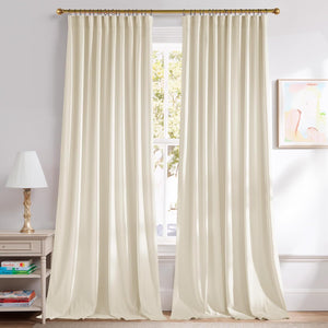 Pair of flowing ivory pleated curtains on a gold rod, covering a large window in a bright room.