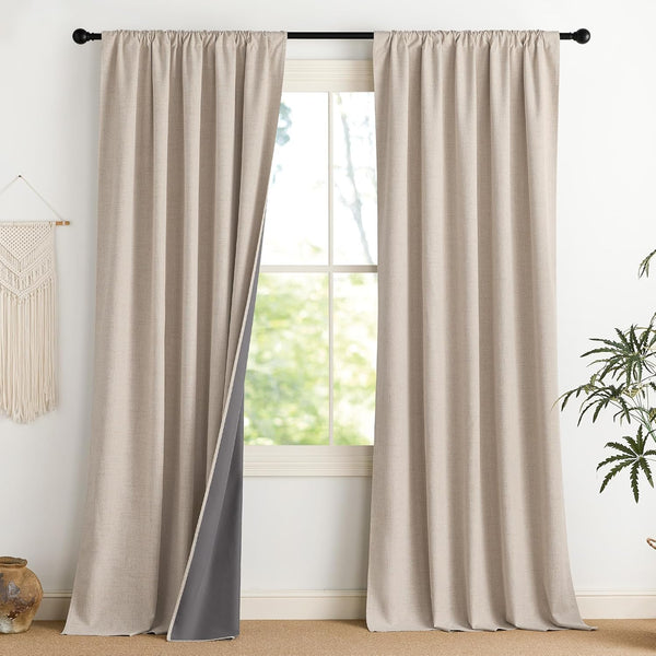 Light beige textured blackout curtain panels with dark gray lining, hung by rod pocket over a window.