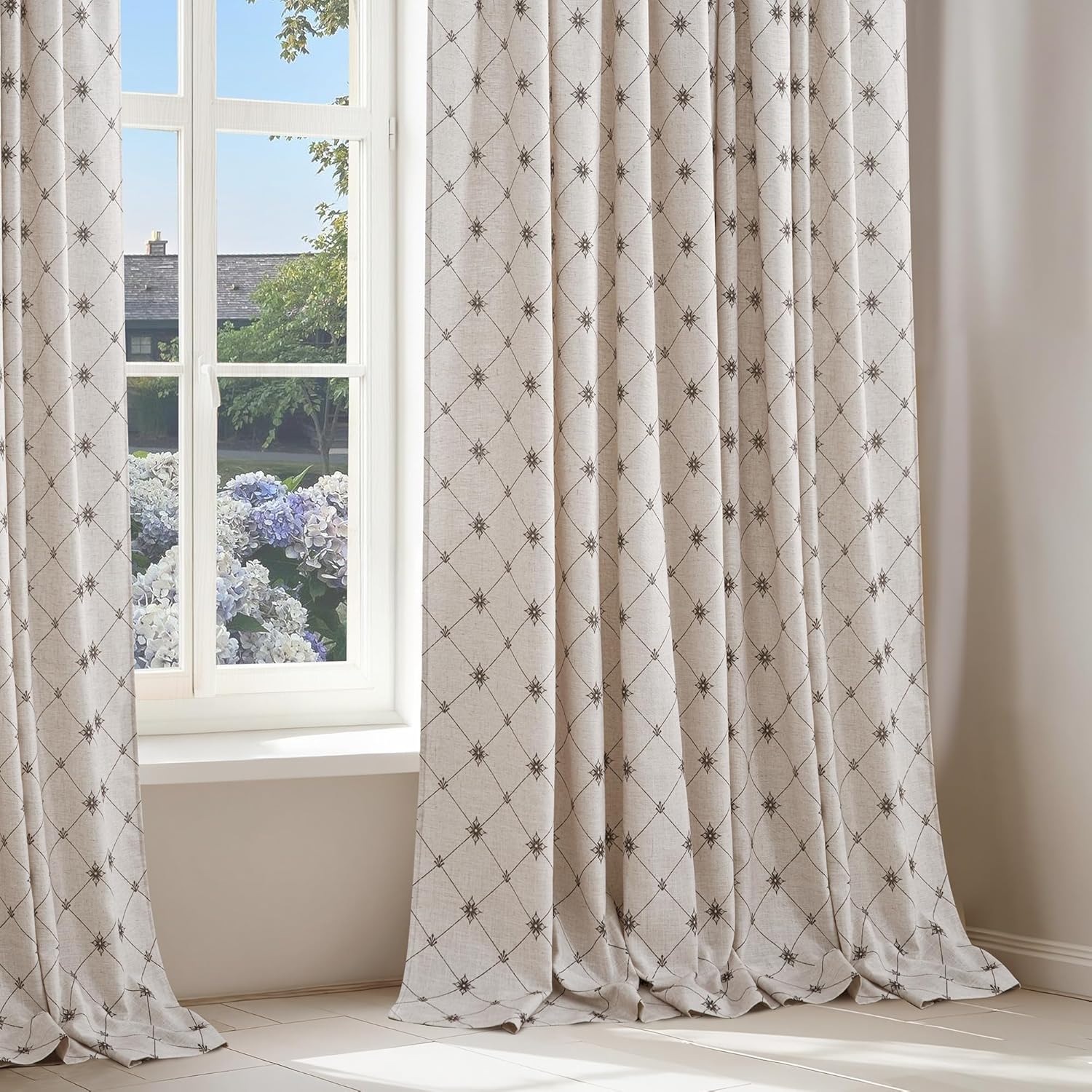Elegant light beige curtains with dark diamond lattice and starburst pattern, framing a window.