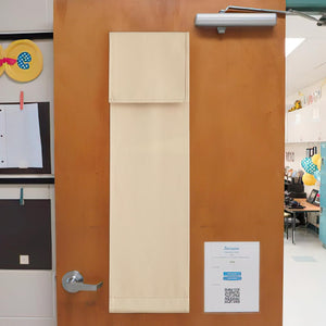 Light beige fabric door privacy shade with stitched edges, hanging on a wooden classroom door.