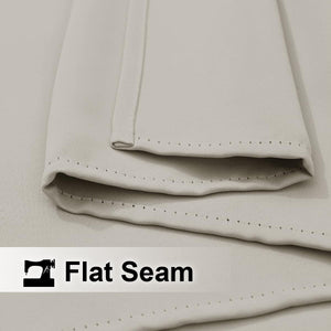 Close-up of a light beige fabric highlighting a neat flat seam with precise, visible stitching.