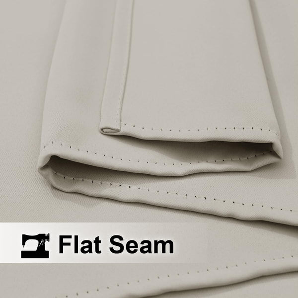 Close-up of a light beige fabric highlighting a neat flat seam with precise, visible stitching.