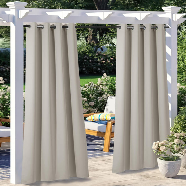 Light beige outdoor curtains with black grommet tops hanging from a white pergola on a sunny patio.