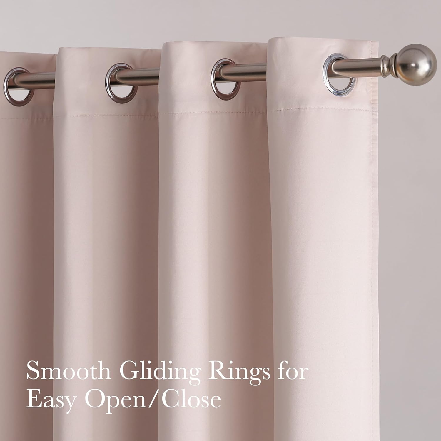 Close-up of light beige grommet top curtains with smooth gliding rings on a brushed nickel rod.