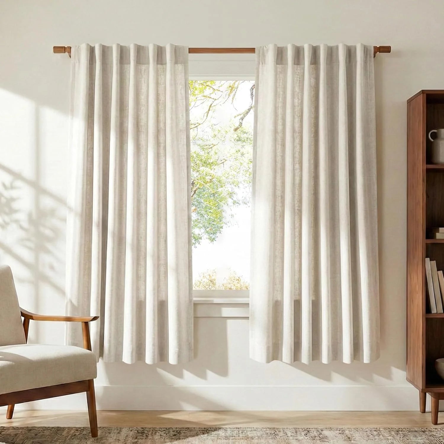 Light beige textured linen blend curtains on a natural wood rod in a bright living room.