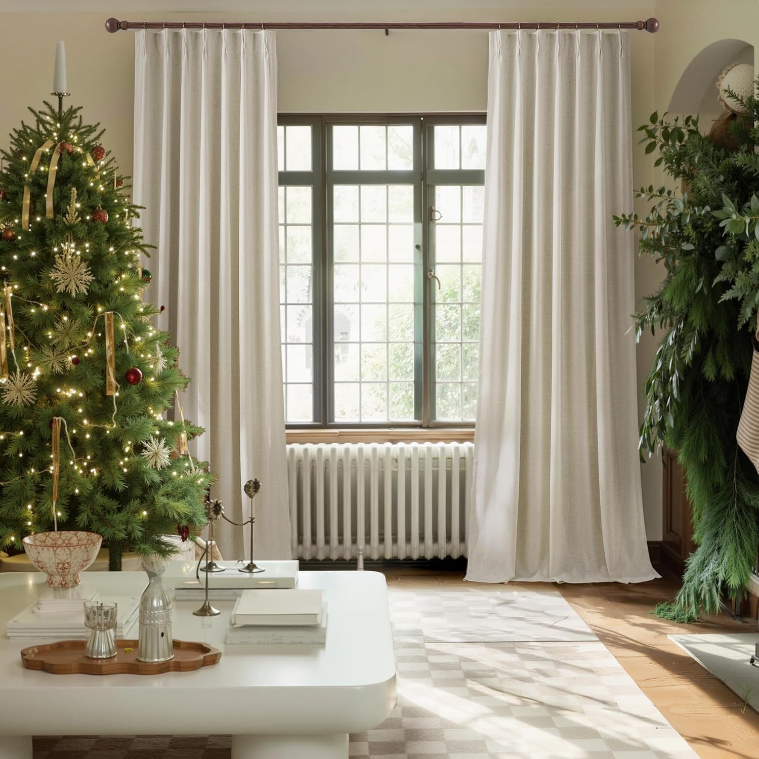 Light beige linen pinch pleat curtains on dark wood rod in a festive living room.