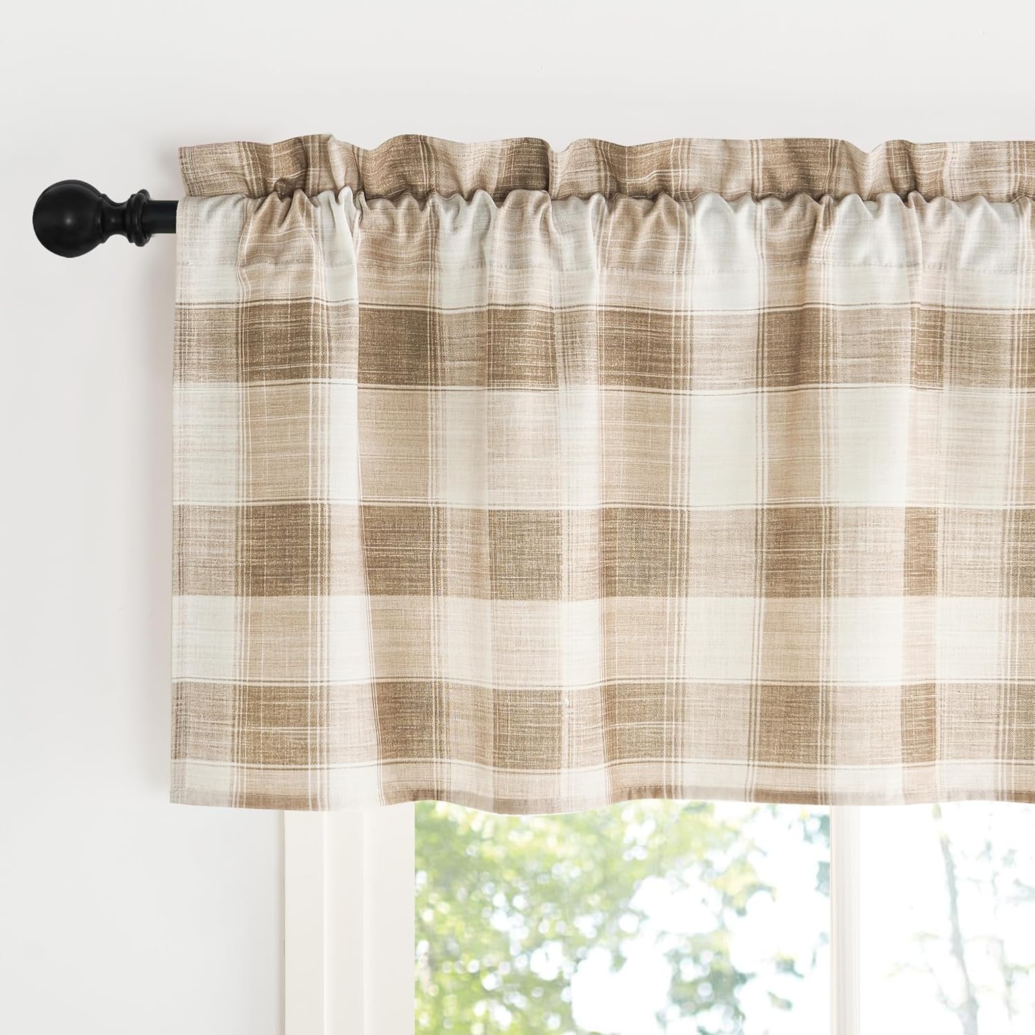 Light beige and cream plaid window valance with a gathered rod pocket, hanging on a black decorative rod.