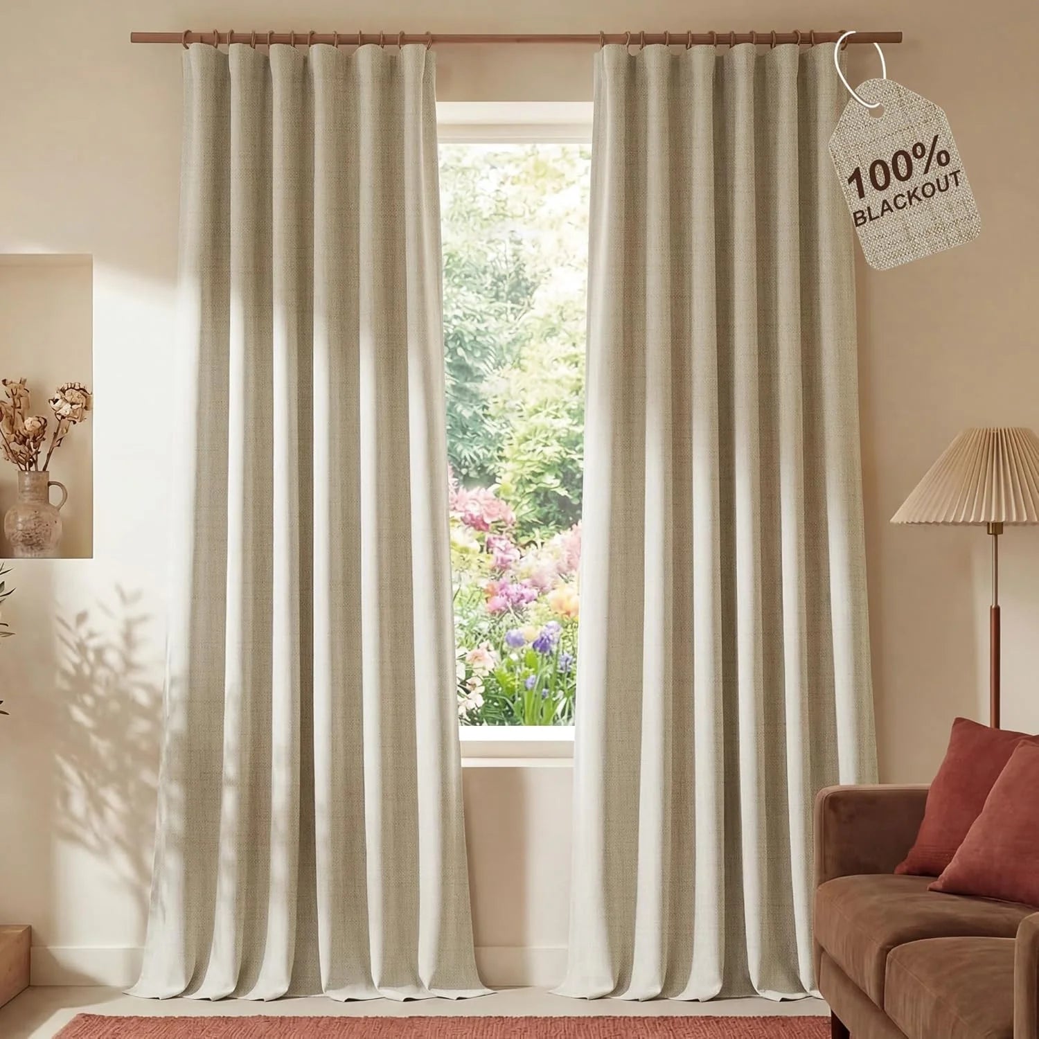 Light beige textured 100% blackout curtains on a wood rod in a bright living room.