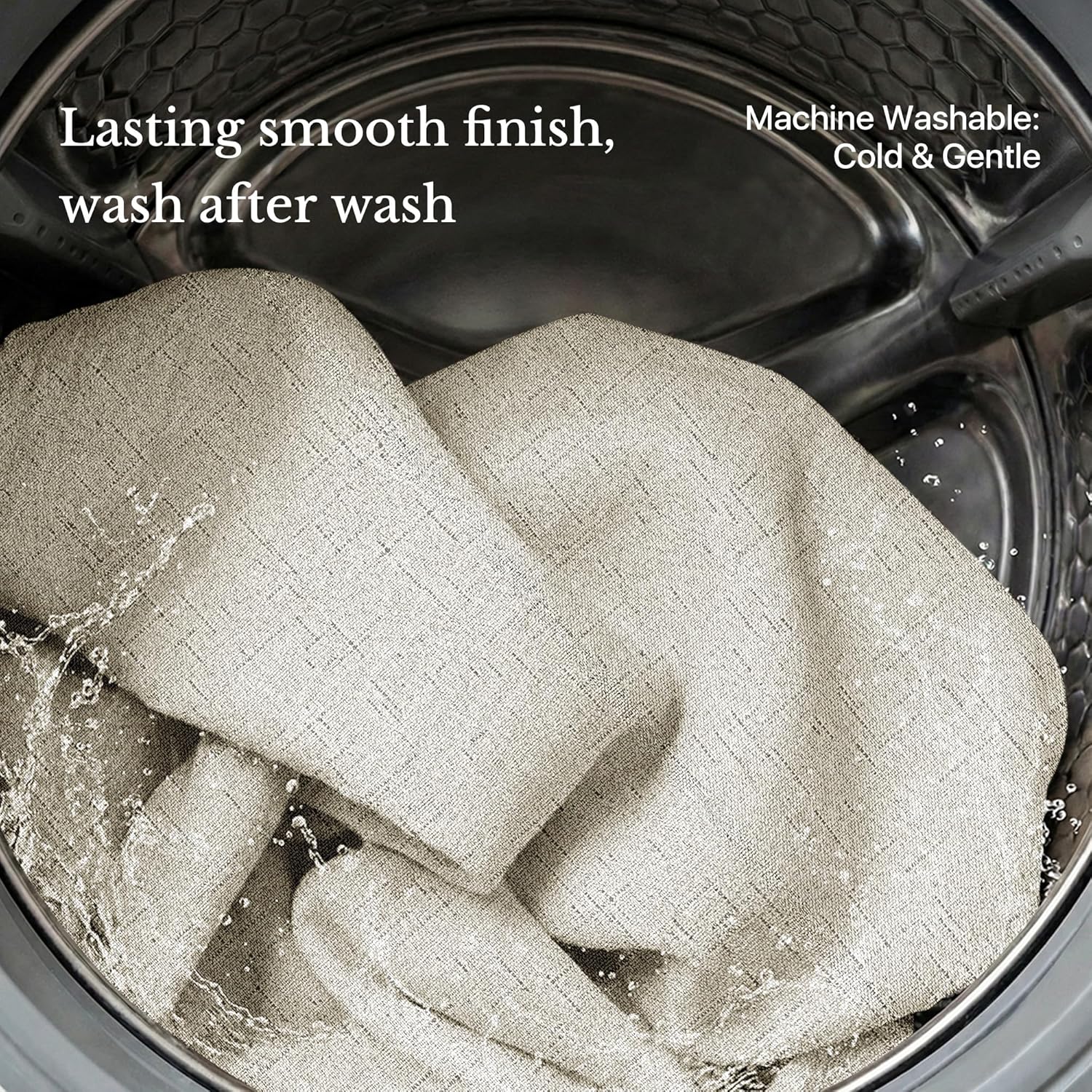 Light beige textured fabric being washed inside a metal washing machine drum with splashing water.