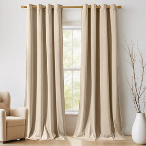 Floor-length light beige velvet curtains with grommet tops on a gold rod, hanging over a window.