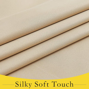 Close-up of light beige woven fabric with a fine diagonal texture, folded to show its smooth and soft drape.