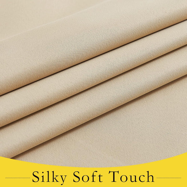 Close-up of light beige woven fabric with a fine diagonal texture, folded to show its smooth and soft drape.