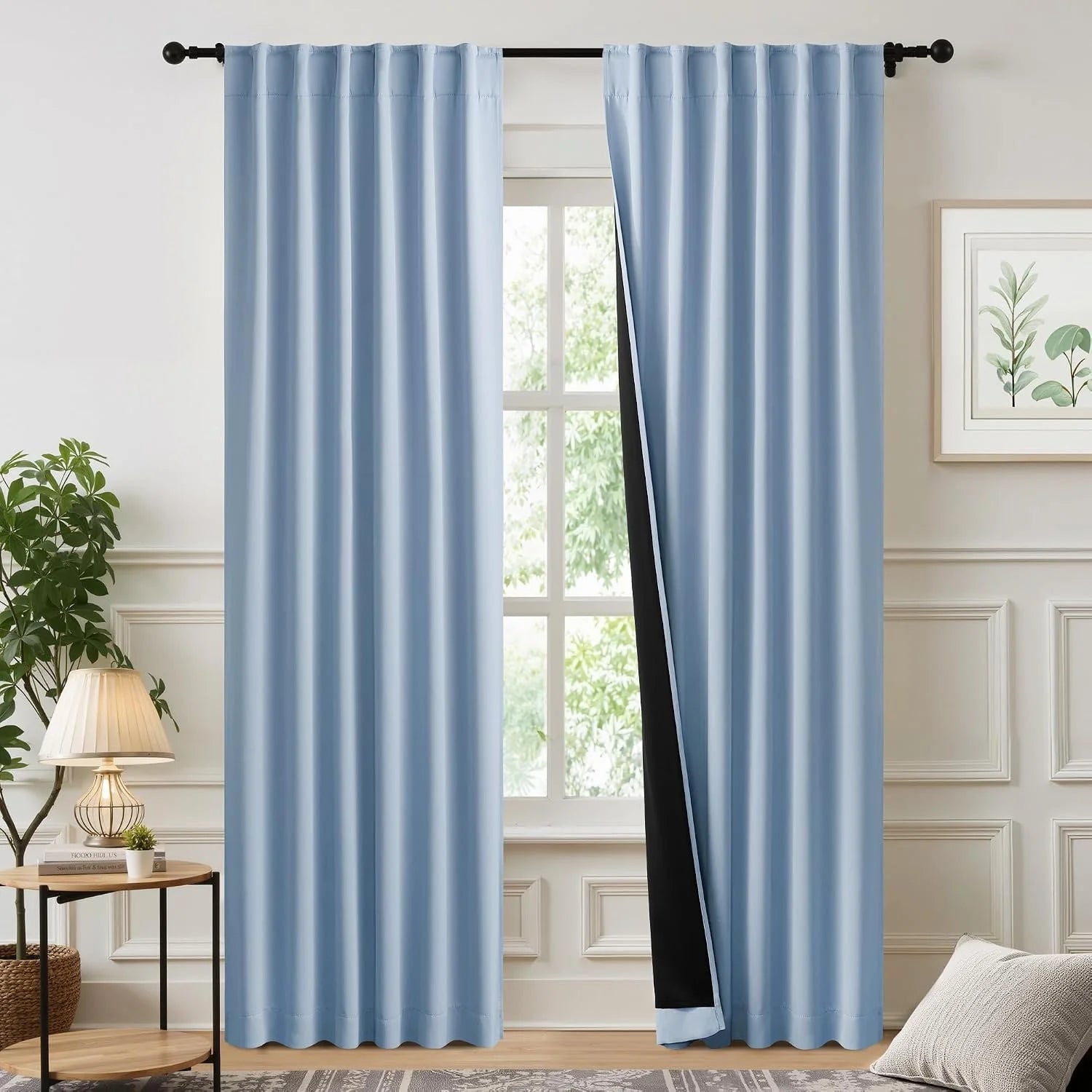 Light blue blackout curtains on a black rod in a bright modern living room