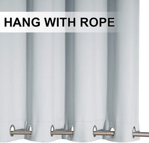 Close-up of light blue blackout curtain panel with silver grommet top on a metal rod