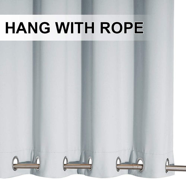 Close-up of light blue blackout curtain panel with silver grommet top on a metal rod