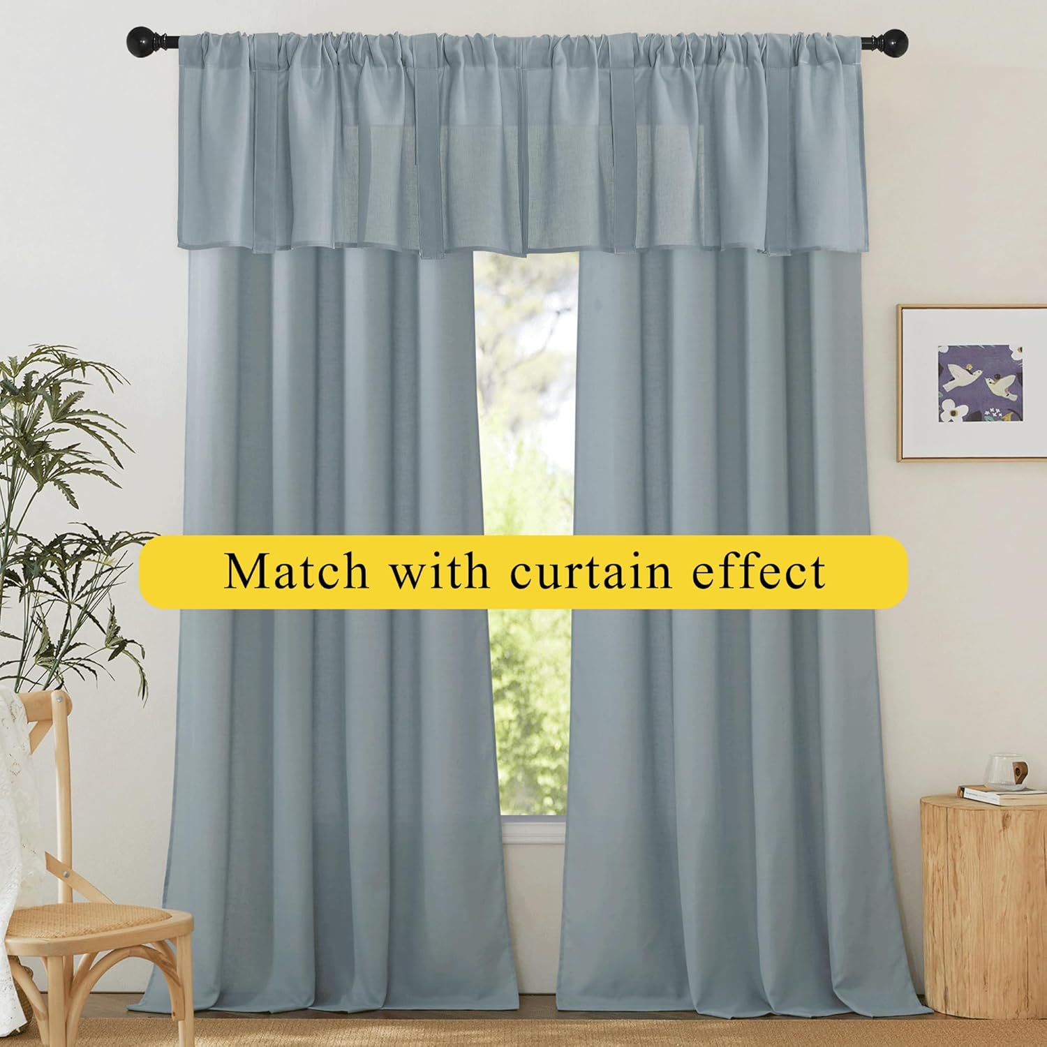 Light blue solid rod pocket curtains with matching gathered valance on a window with a black rod.