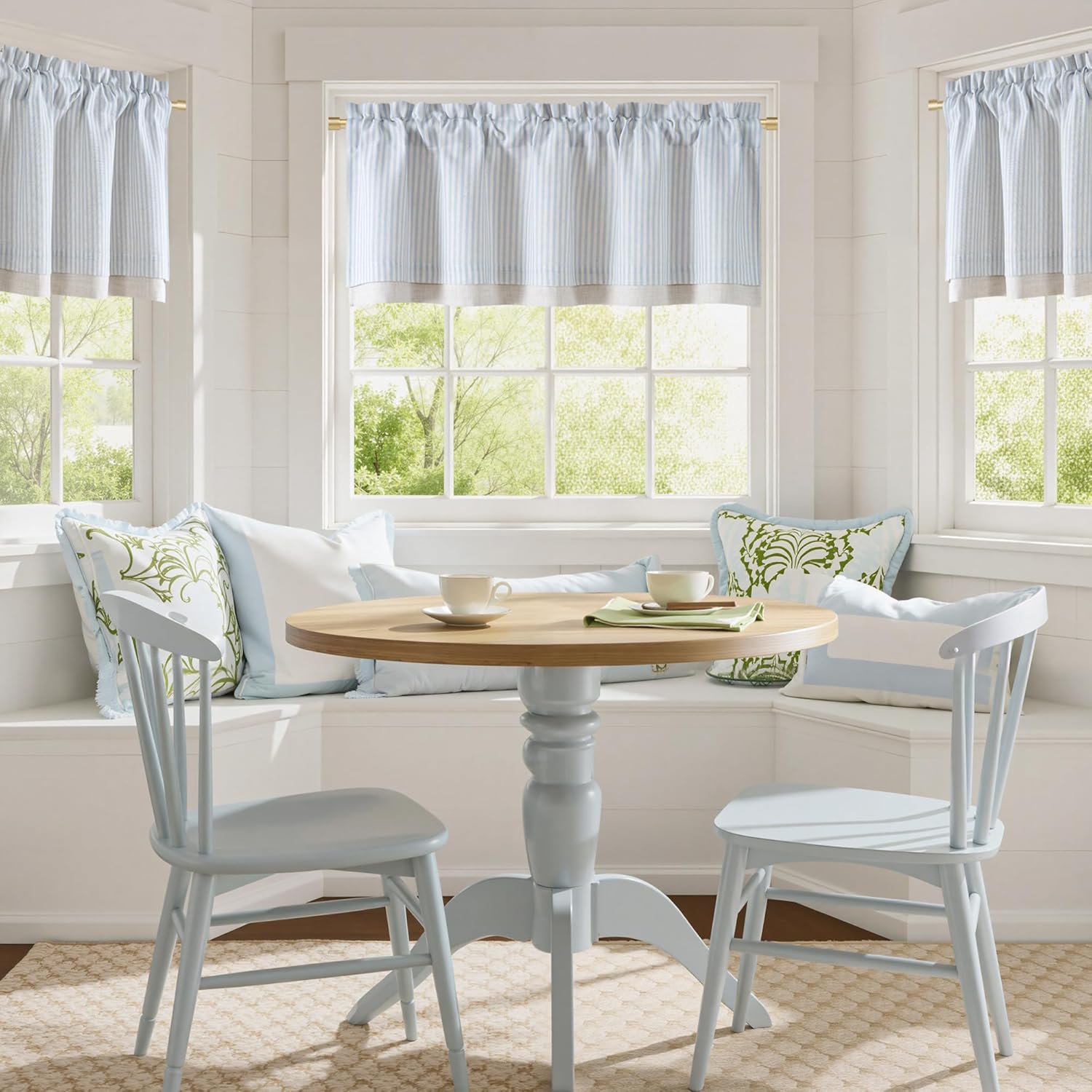 Light blue striped gathered valance curtains with beige trim, enhancing a cozy kitchen breakfast nook.