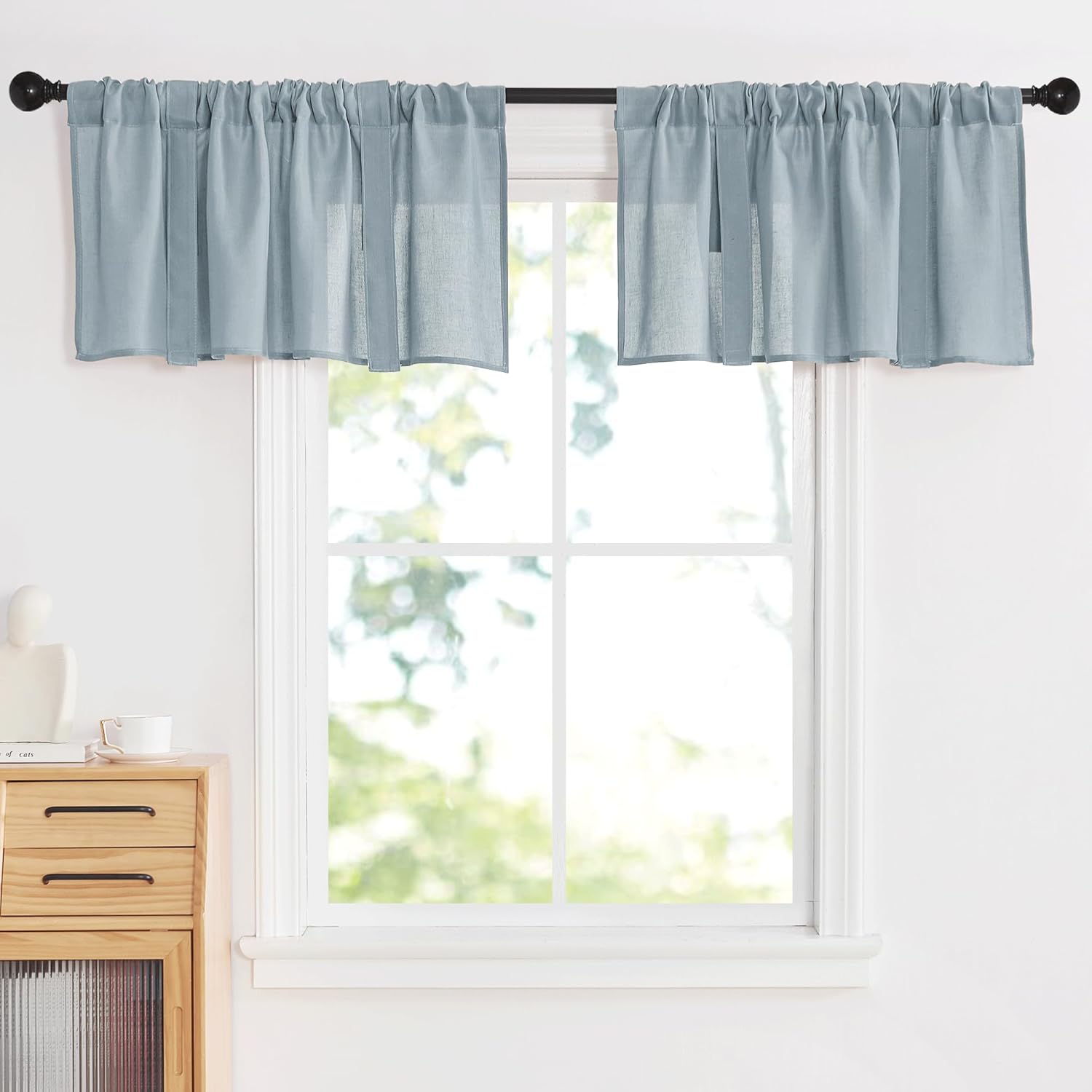 Light blue textured window valance with a gathered rod pocket, hung on a dark curtain rod.