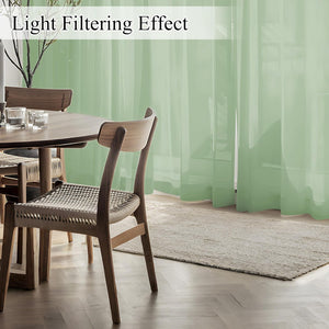 Sage green sheer curtains softly filtering sunlight in a modern dining room.